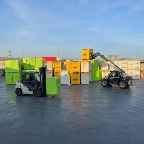 Навантажувач відвантажує палету газоблоку на складі